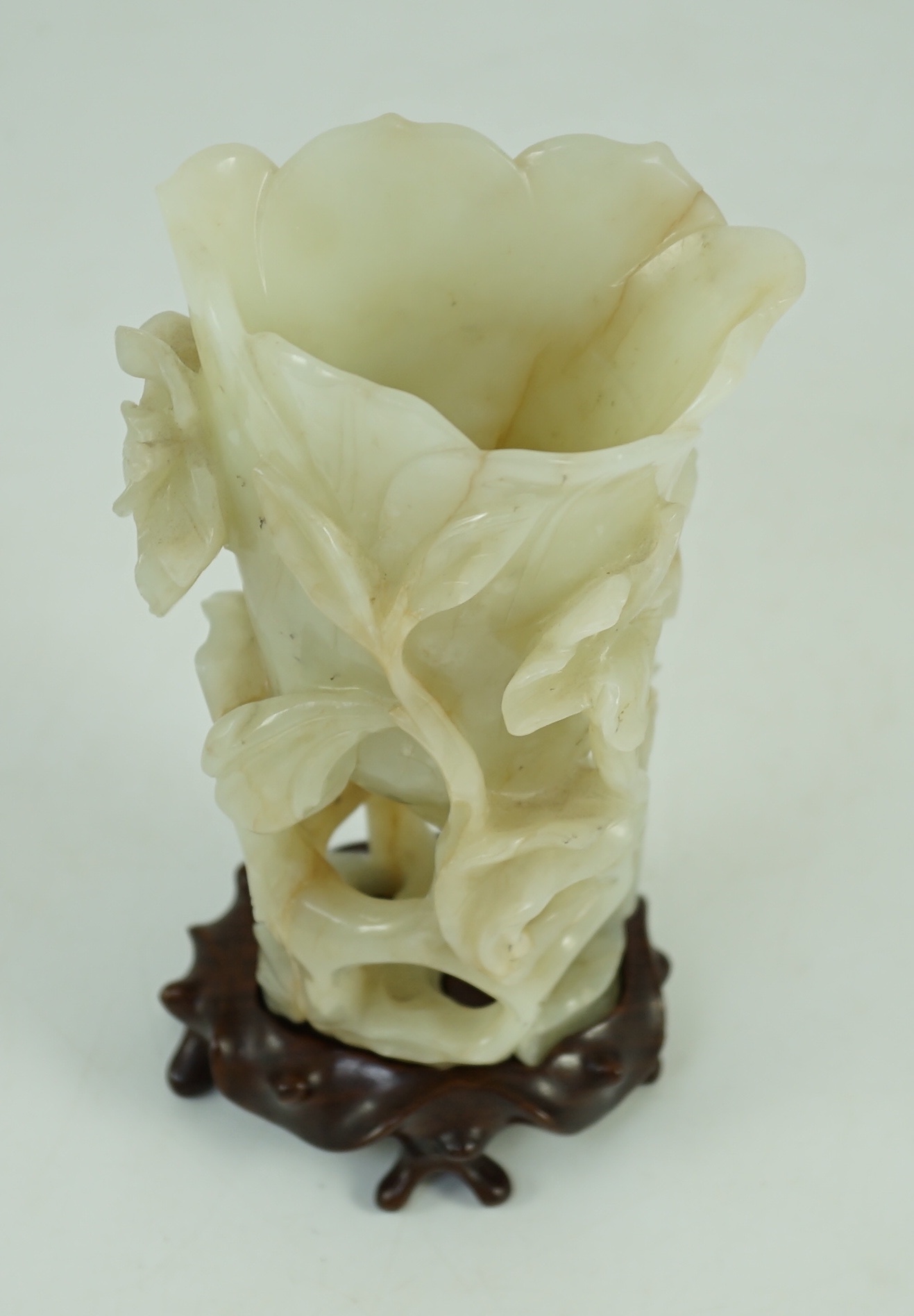 A large Chinese pale celadon jade ‘magnolia’ cup, 17th/18th century 17.5cm high excluding wood stand